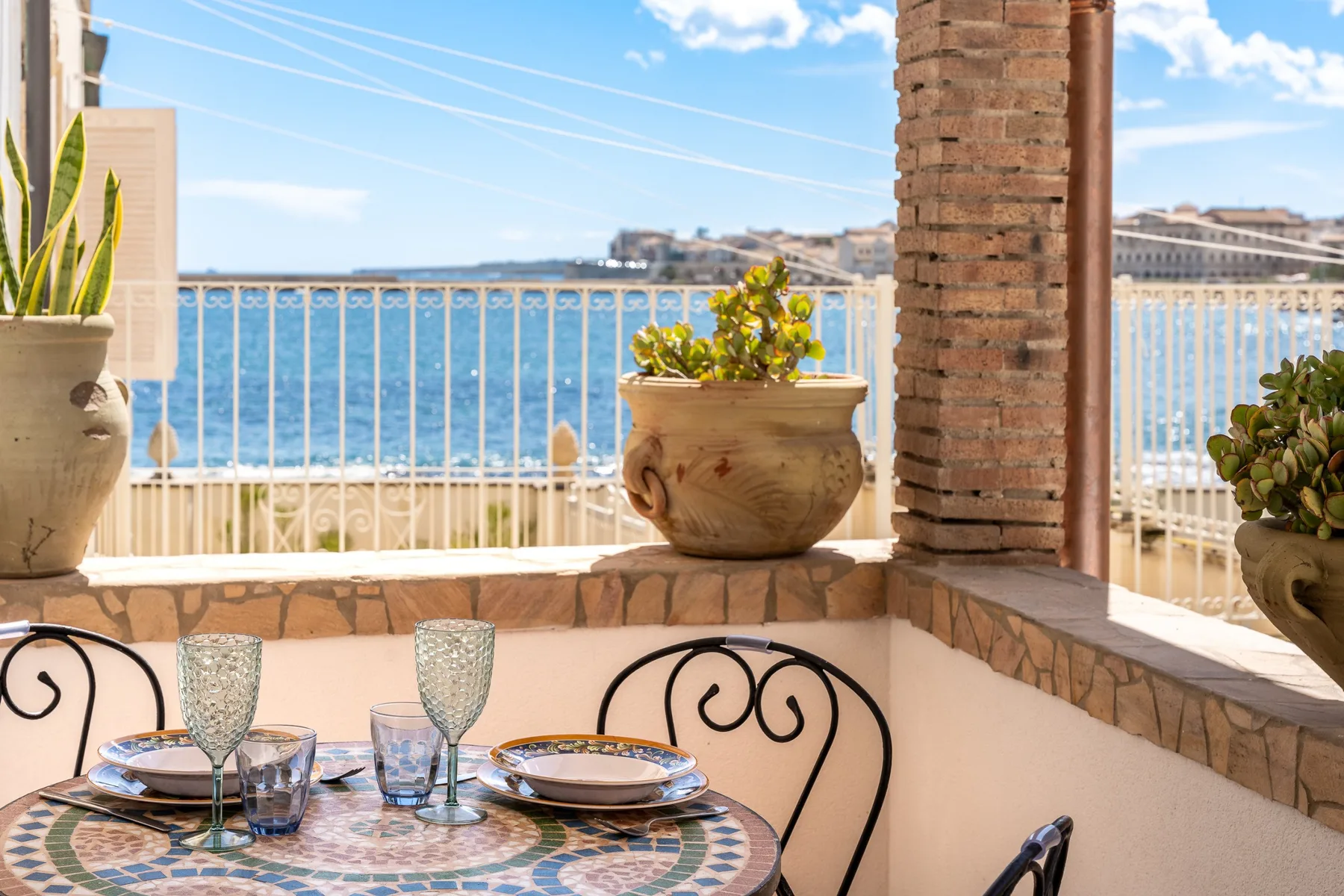 Una zona de comedor exterior con azulejos da al agua desde una terraza.
