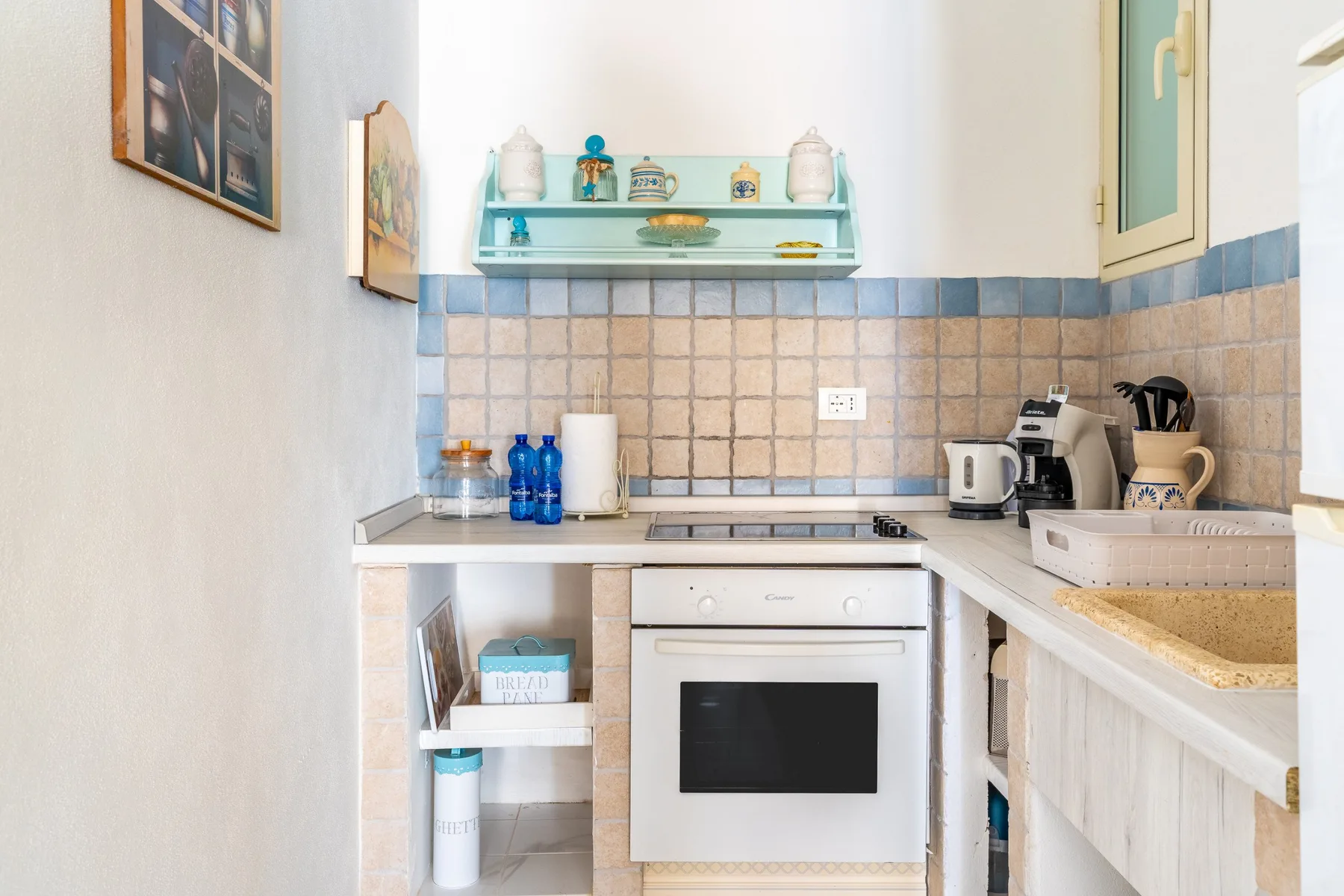 Una cocina compacta con placa de cocción, horno y fregadero.