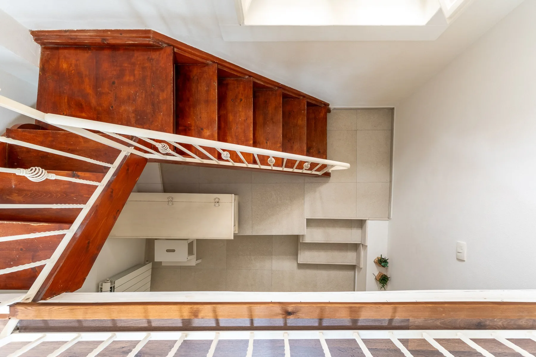 Una cocina compacta con gabinetes de madera, una campana extractora y estantes abiertos.