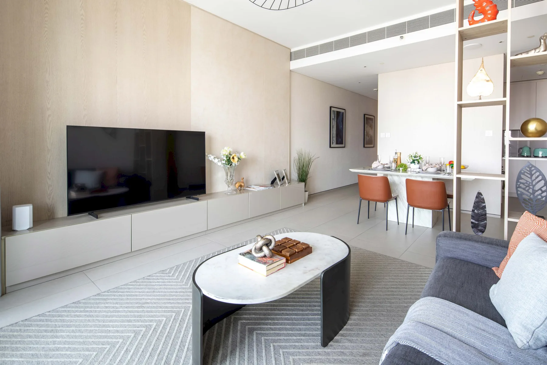 Una luminosa sala-comedor diáfana con televisor y mesa de comedor.