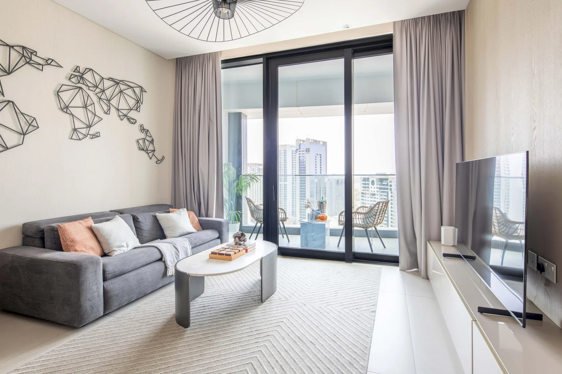 A bright living room with seating, a coffee table, and sliding glass doors.