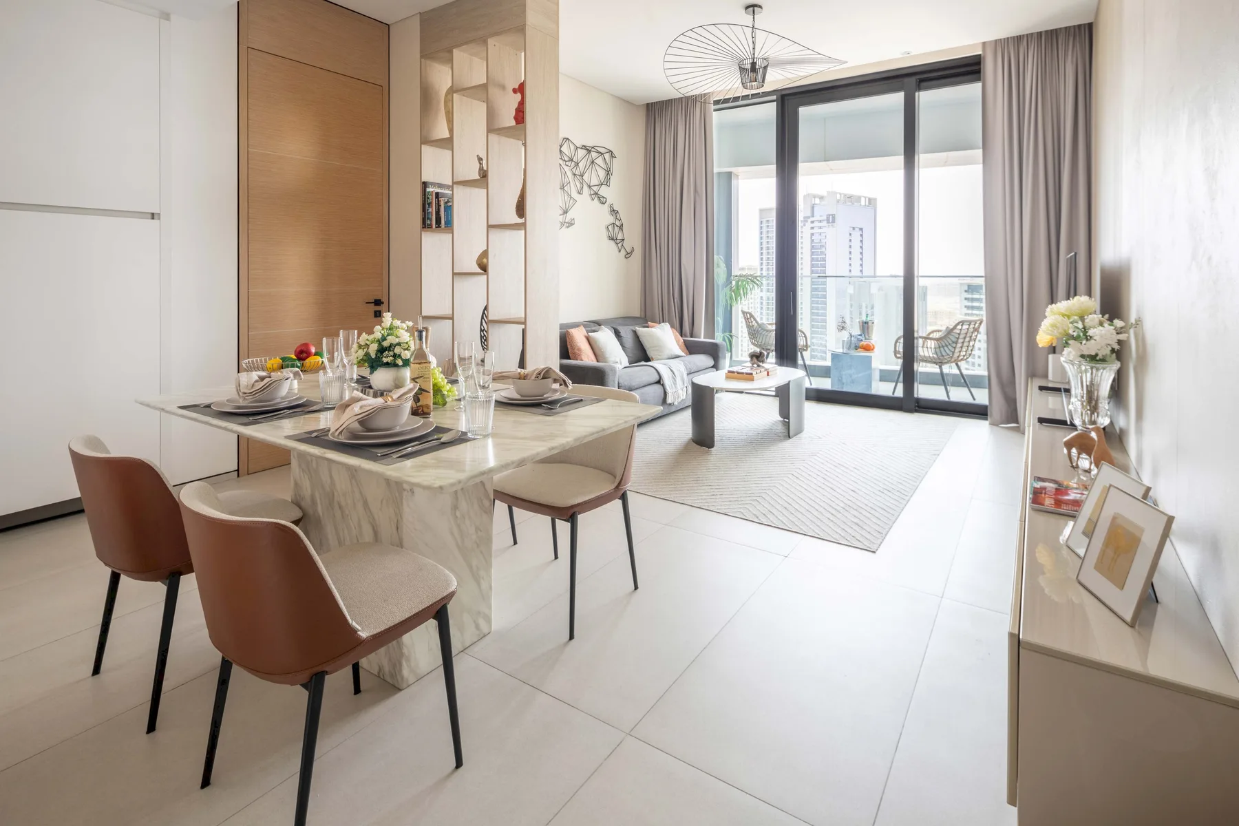Una luminosa sala de estar y comedor de planta abierta, con la mesa puesta y asientos.