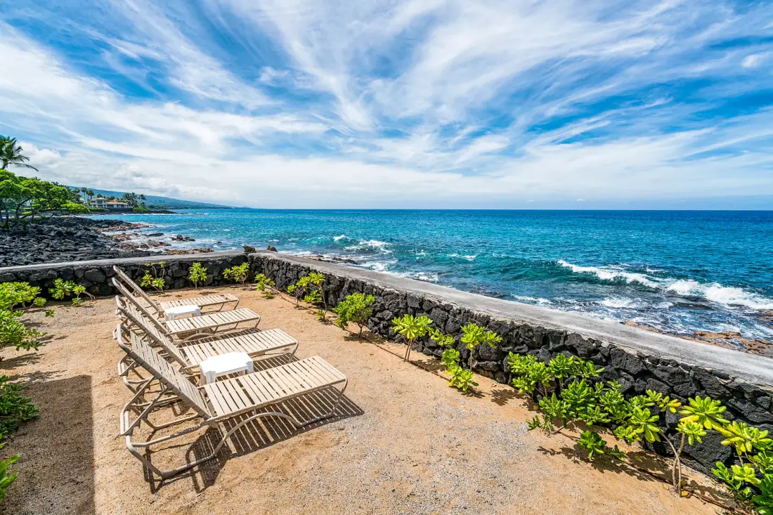 Un patio junto al mar con asientos de descanso da al océano.