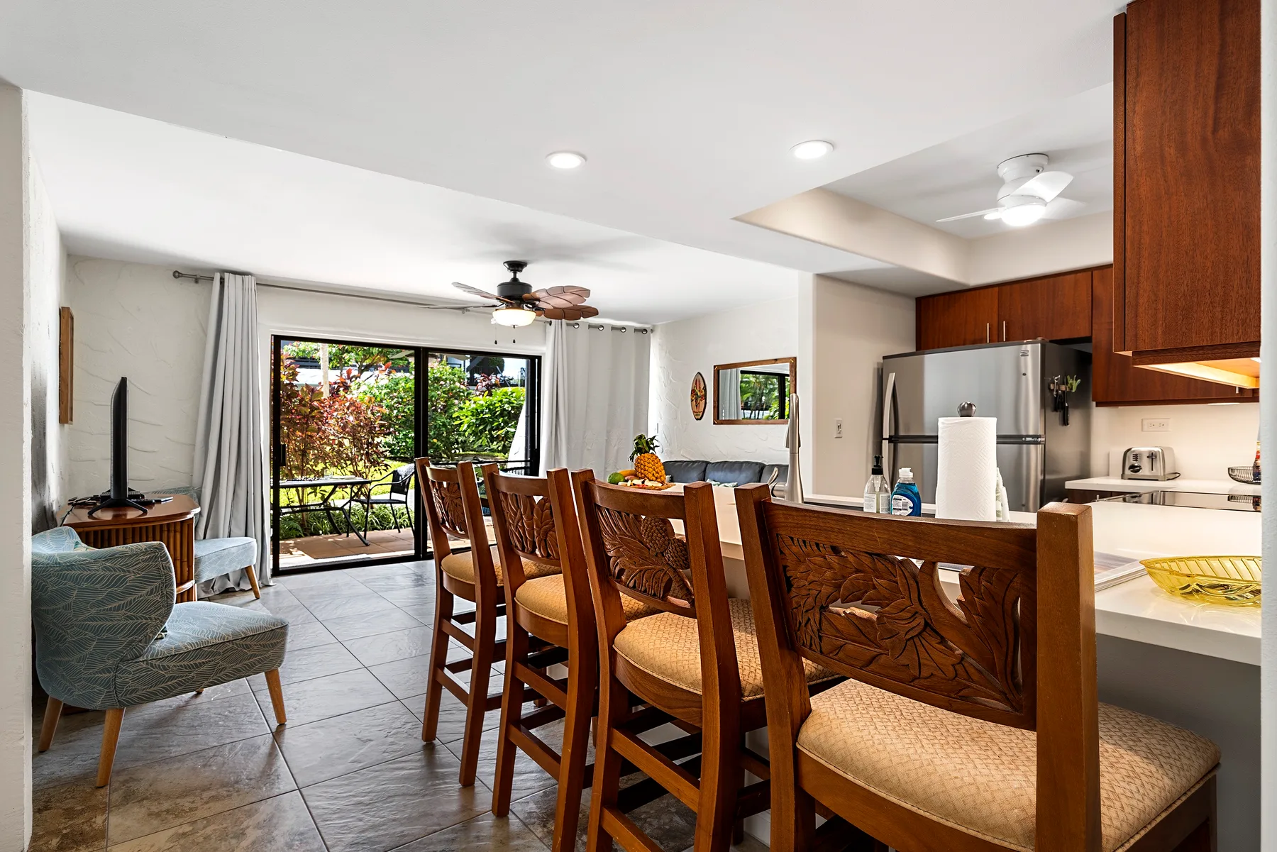 Un comedor se abre a una cocina, con una mesa junto a puertas corredizas de vidrio.