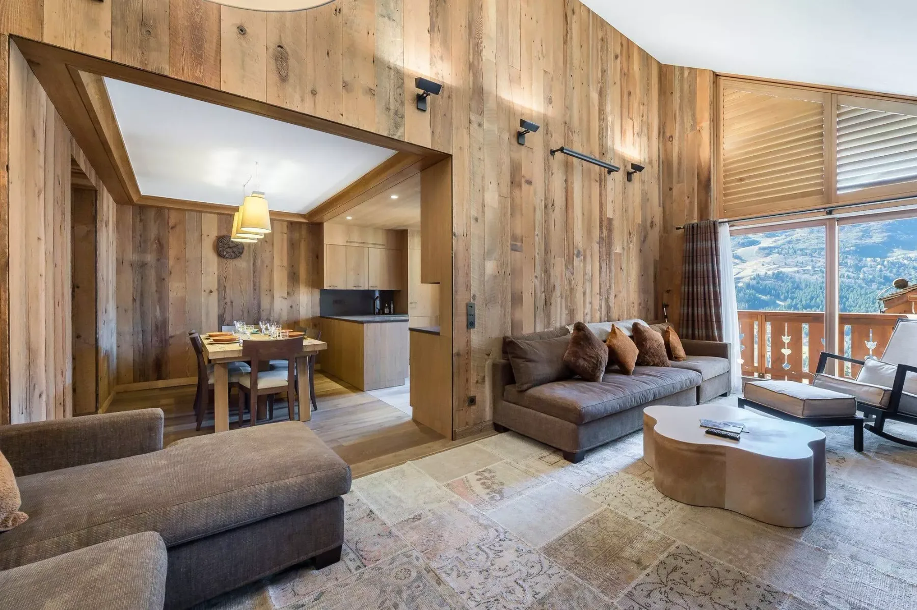 A wood-paneled living room with seating and a dining area.