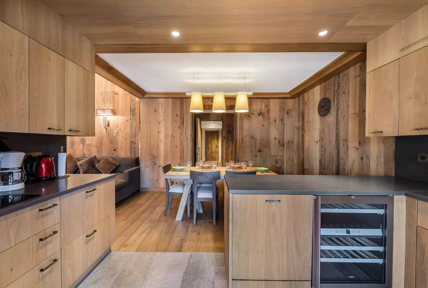 A wood-paneled kitchen and dining area with a central island and dining table.