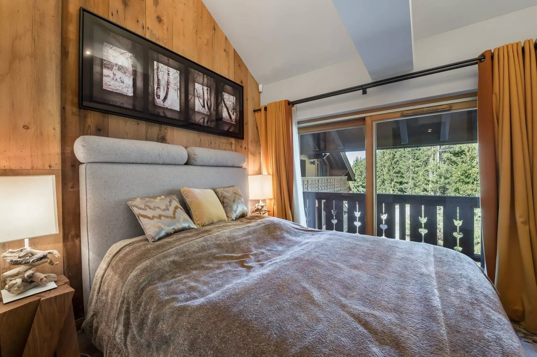 A bedroom with a large bed and sliding glass doors opening to a balcony.