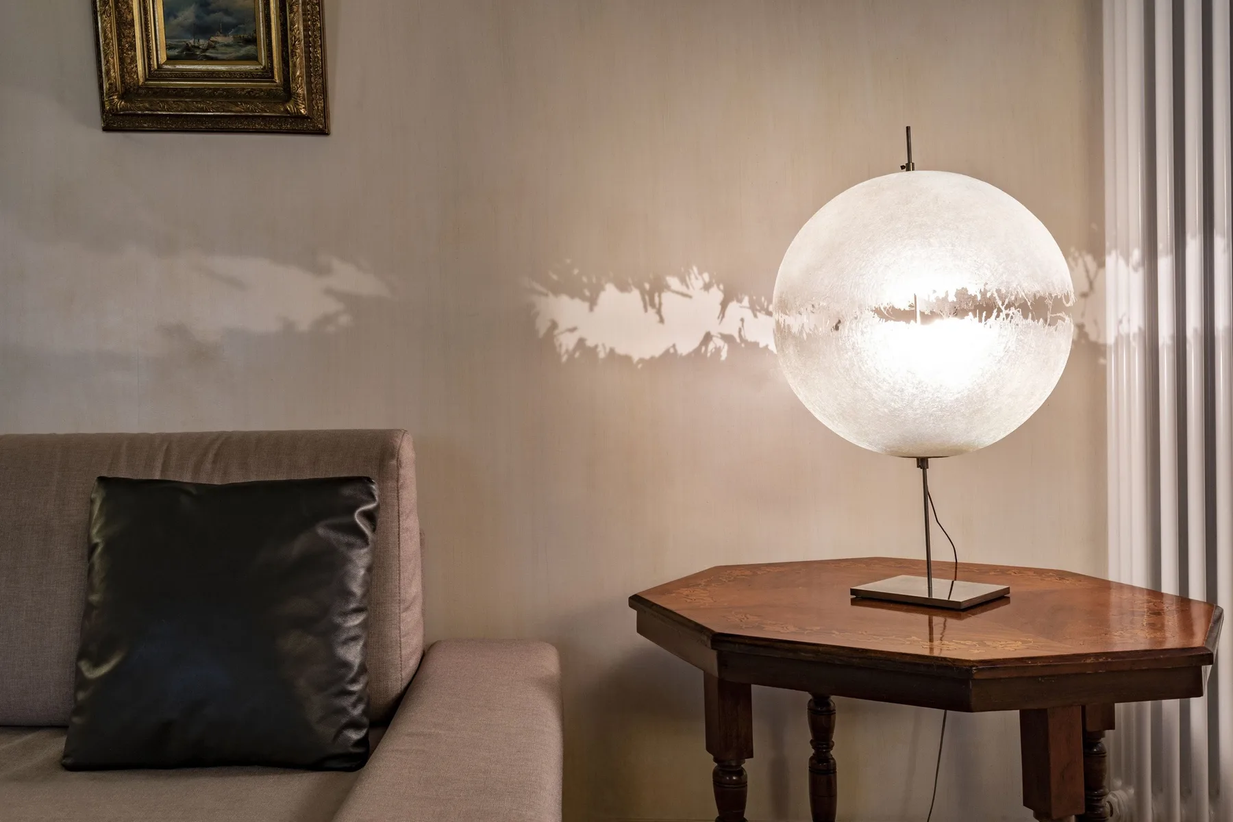 A living room seating area beside a wooden table and glowing pendant lamp.