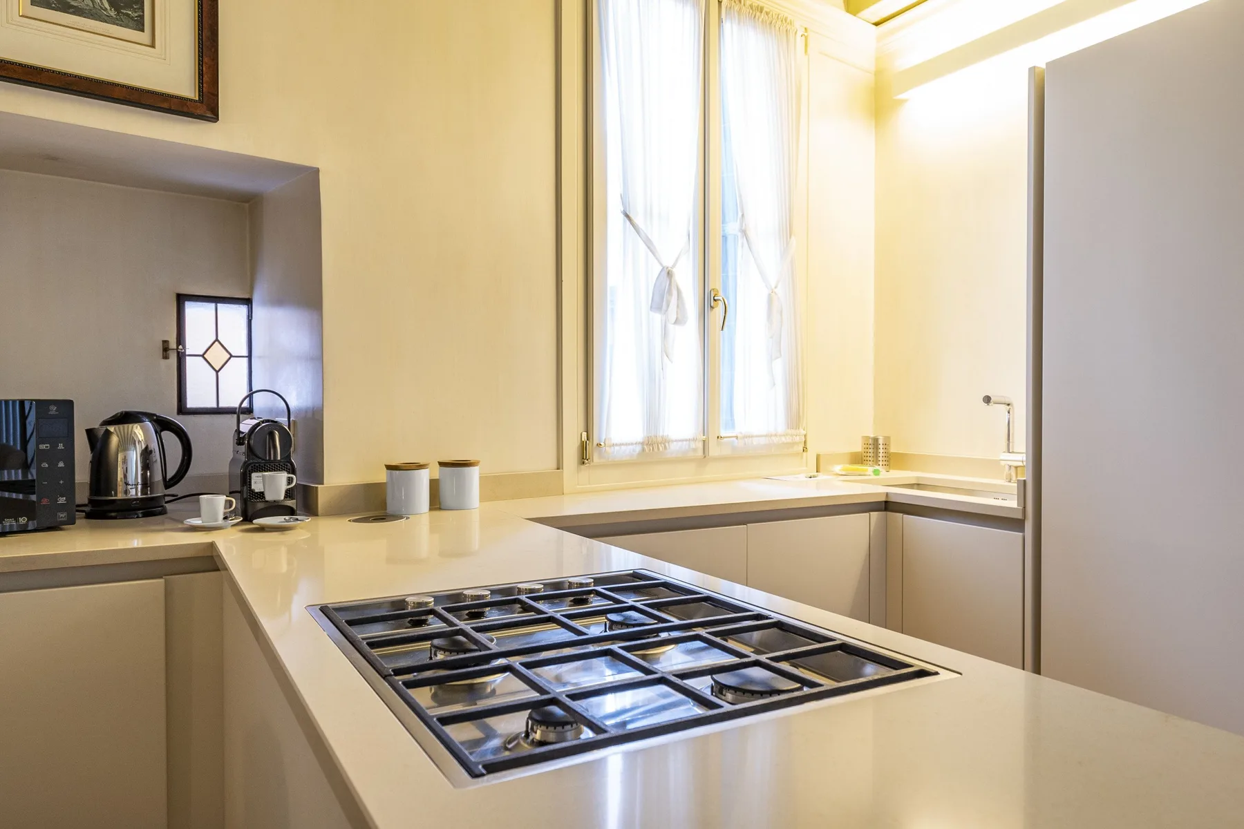 A bright kitchen with a gas cooktop set into a central counter.