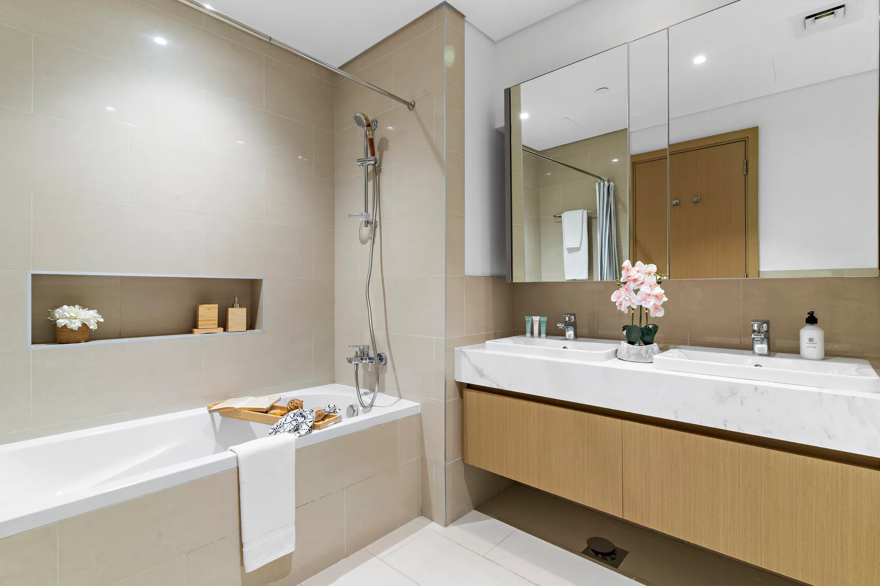 Un baño con azulejos, bañera, ducha y un amplio lavabo.
