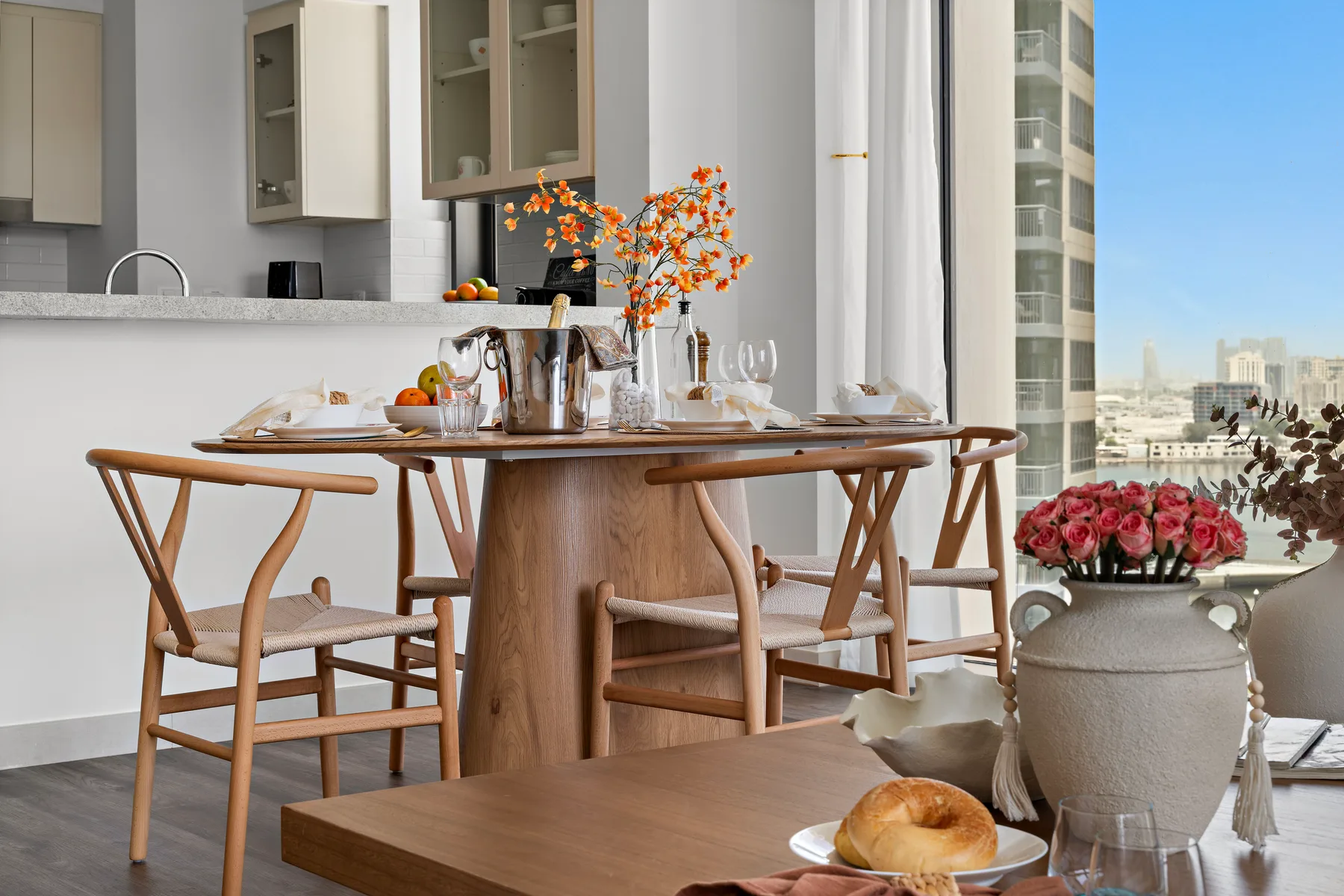 Comedor con una mesa de madera puesta junto a una ventana luminosa.