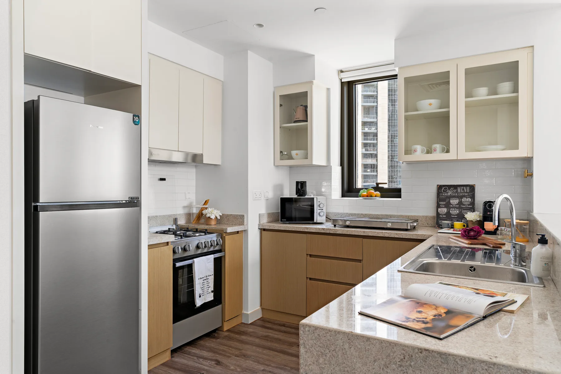 Una cocina luminosa con gabinetes de madera, electrodomésticos de acero inoxidable y una encimera.