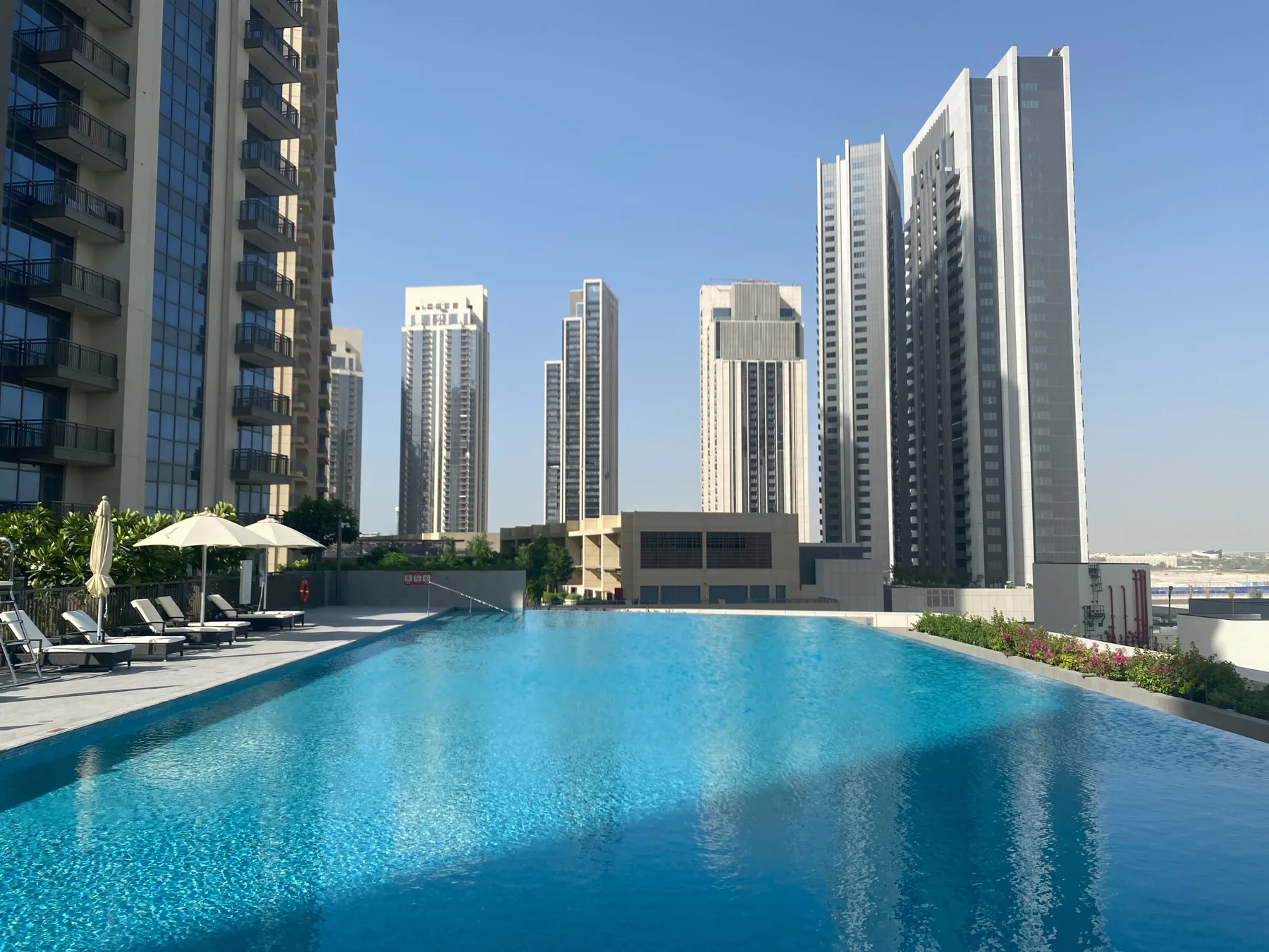 Una piscina en la azotea tiene vistas a un conjunto de edificios altos.