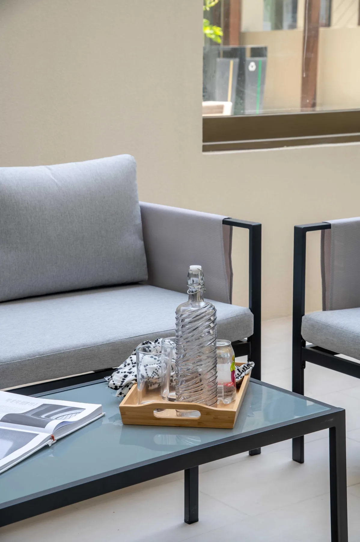 Una zona de estar con una mesa de centro de vidrio y bebidas.