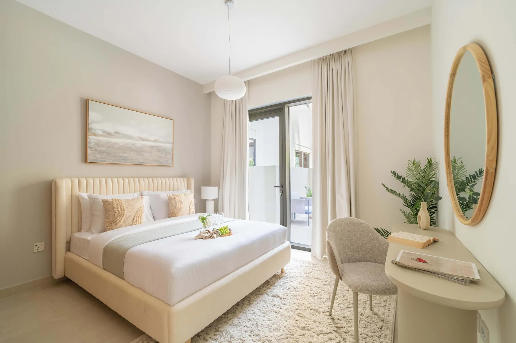 Un dormitorio luminoso con una cama bien tendida y un escritorio junto a la ventana.