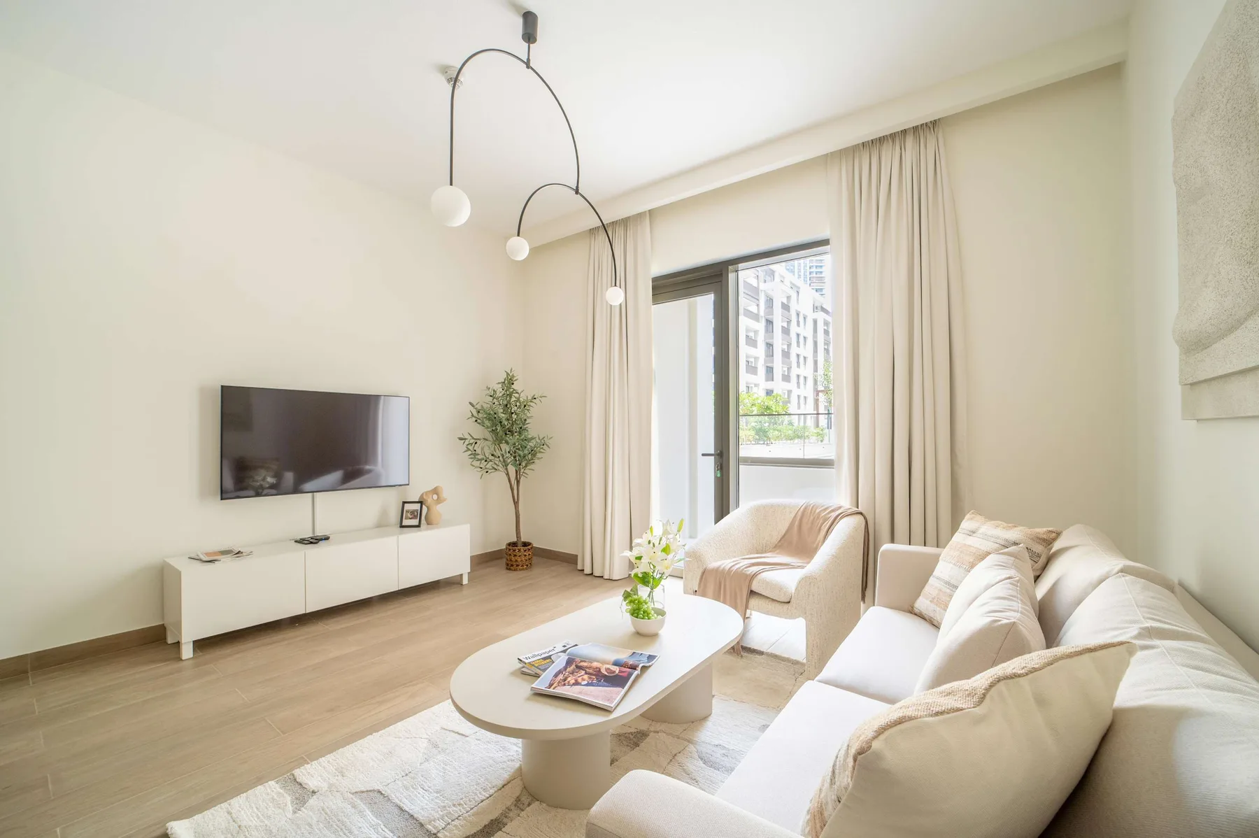 Una sala luminosa con asientos, un televisor y una mesa de centro.