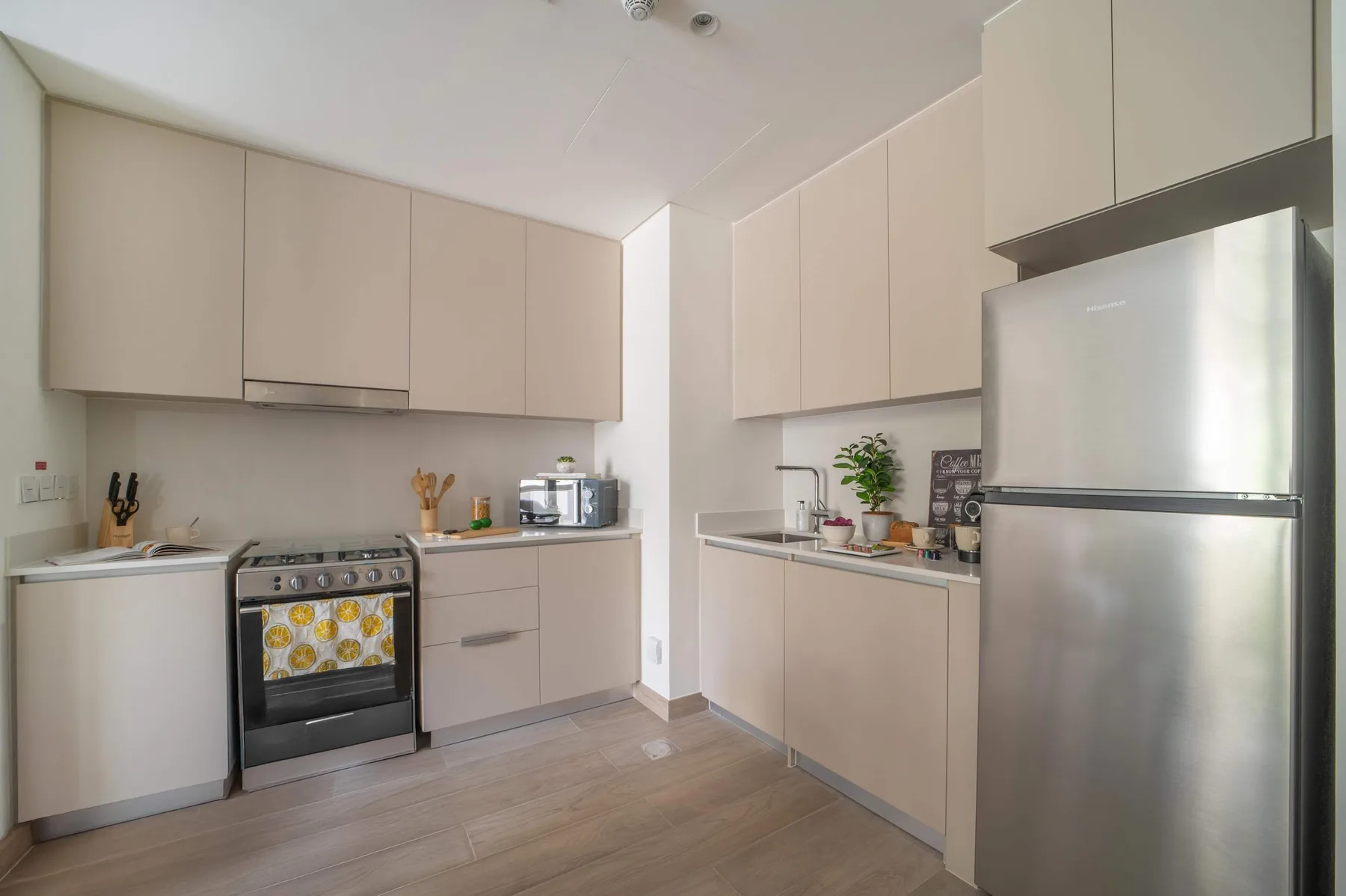 Una cocina moderna con gabinetes claros, encimeras y electrodomésticos de acero inoxidable.
