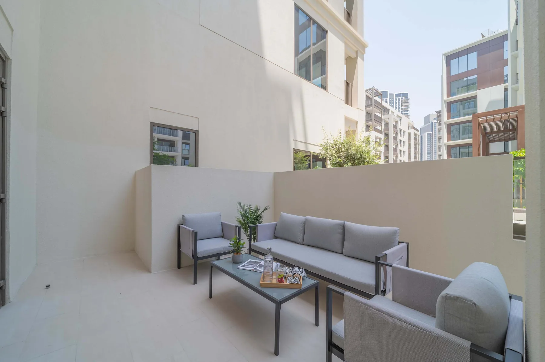 Una zona exterior para sentarse con asientos acolchados y una mesa baja.