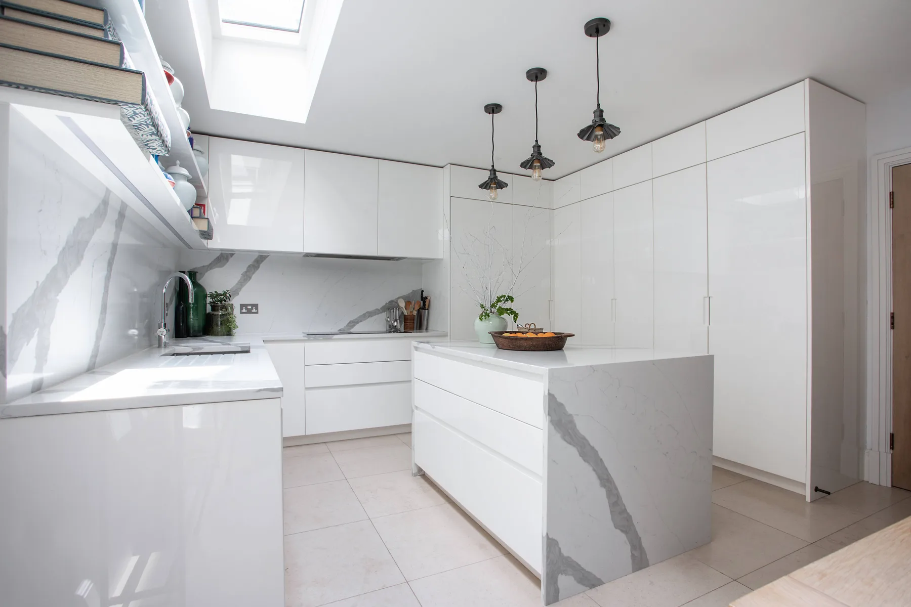 Una cocina moderna y luminosa con gabinetes blancos e isla central.