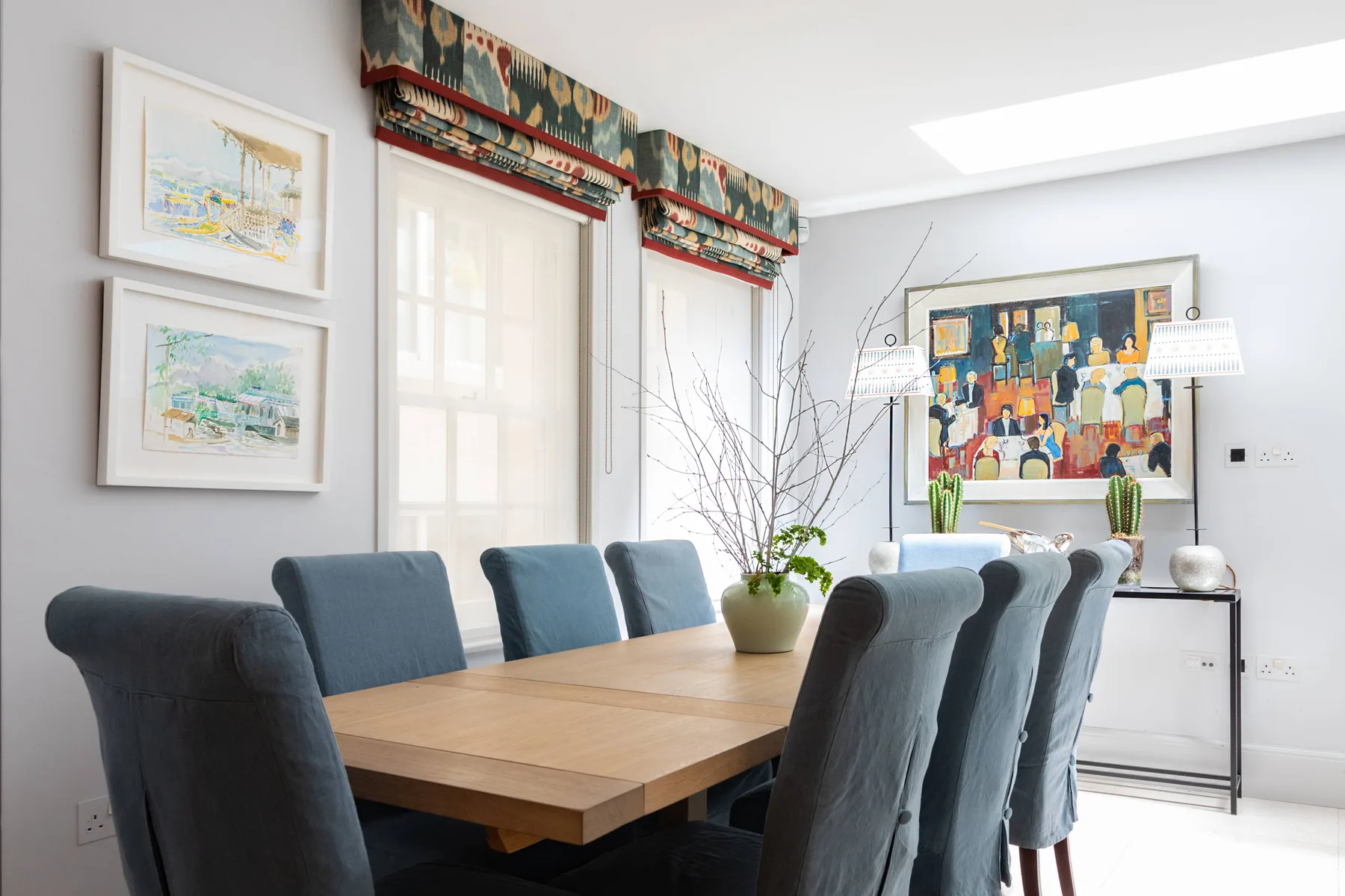 A bright dining room with a wooden table and upholstered seating.