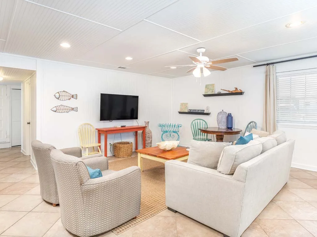 A bright living room with seating arranged around a wooden coffee table.