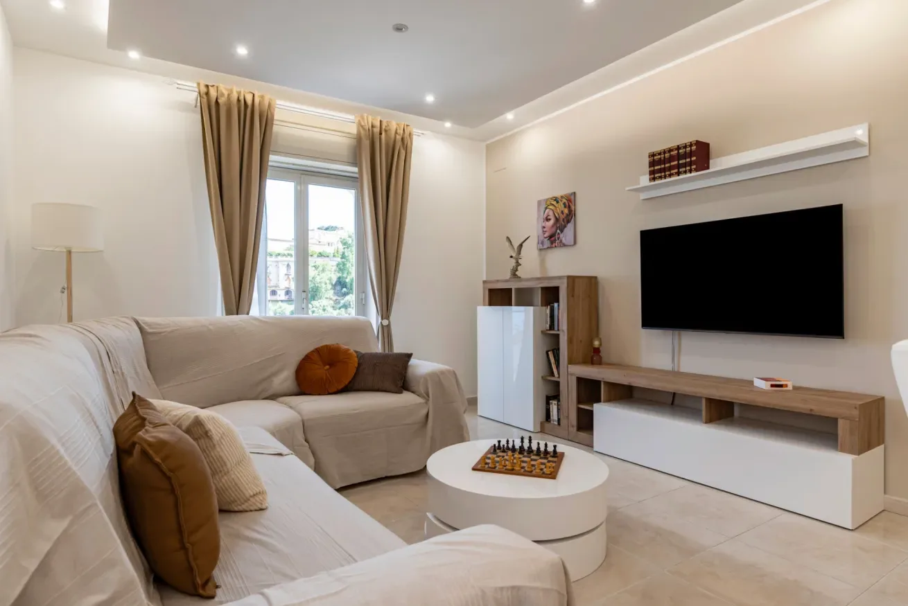 Una sala luminosa con asientos, una mesa de centro y un televisor.
