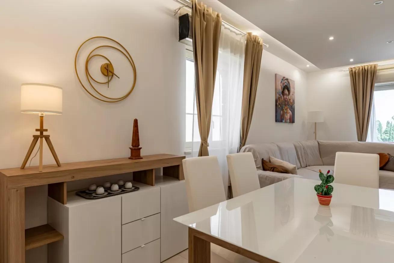 Una luminosa sala de estar y comedor con mesa blanca y asientos.