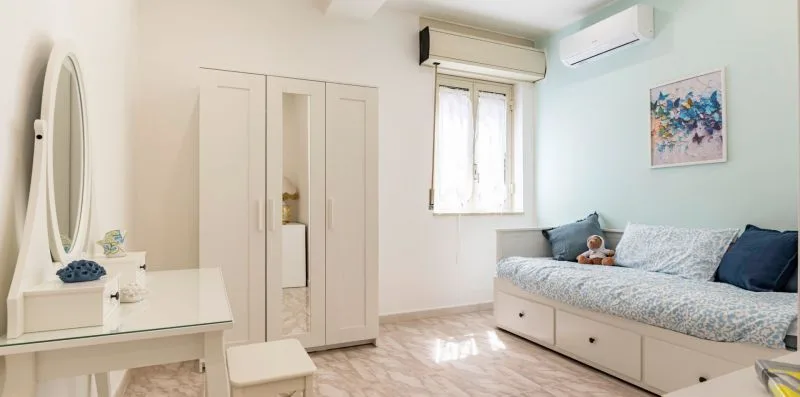 Un dormitorio con cama, armario y tocador.