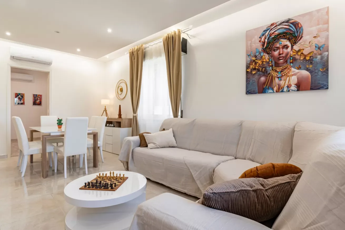 Una luminosa sala de estar y comedor con asientos, una mesa y grandes ventanas.