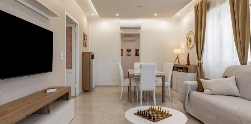 Una luminosa sala de estar y comedor con un tablero de ajedrez sobre una mesa baja.