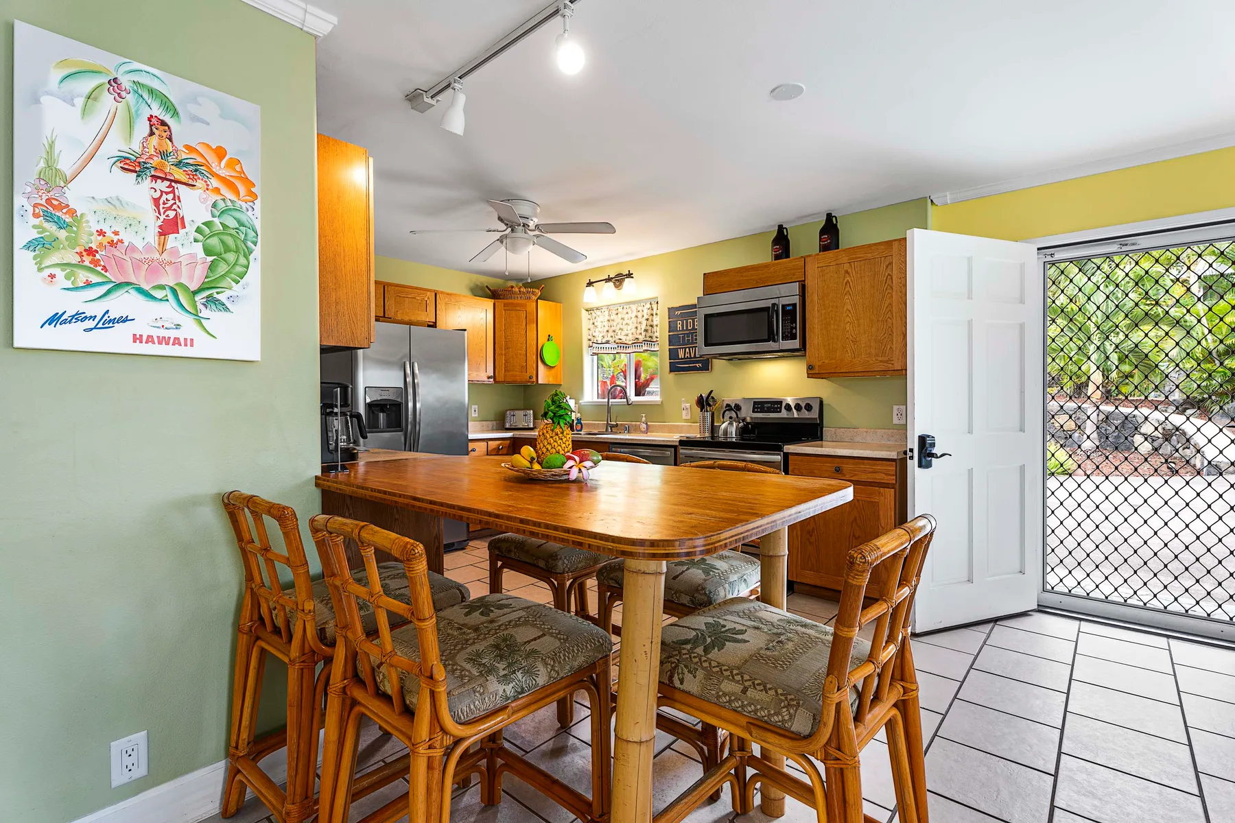 Cocina y comedor con una mesa de madera y una puerta exterior abierta.