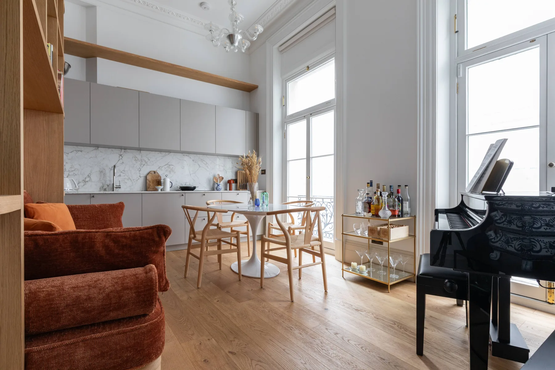 Una luminosa sala de estar y comedor con mesa, asientos y un piano.