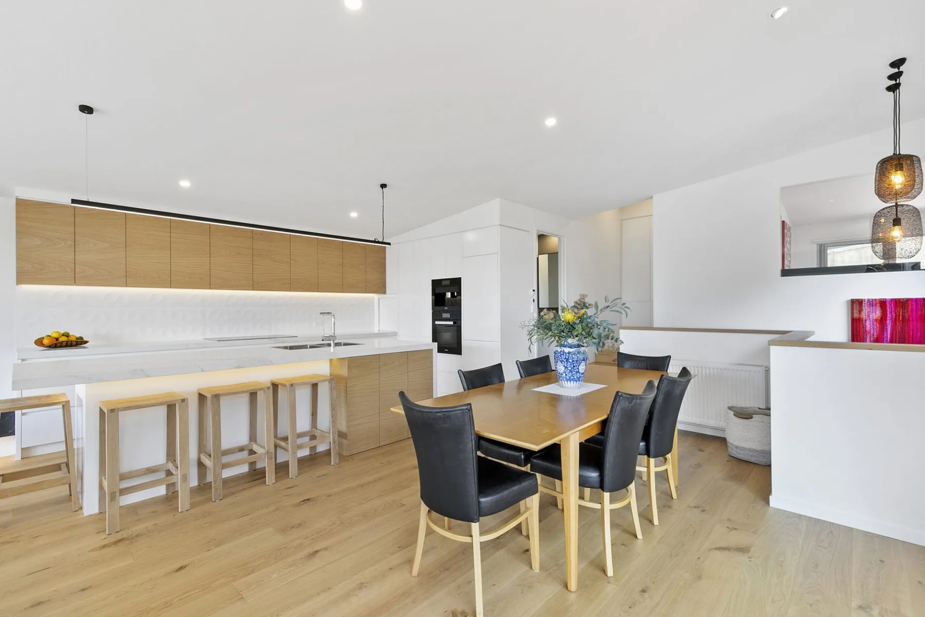 Una cocina moderna con zona de comedor, una encimera larga y una mesa.
