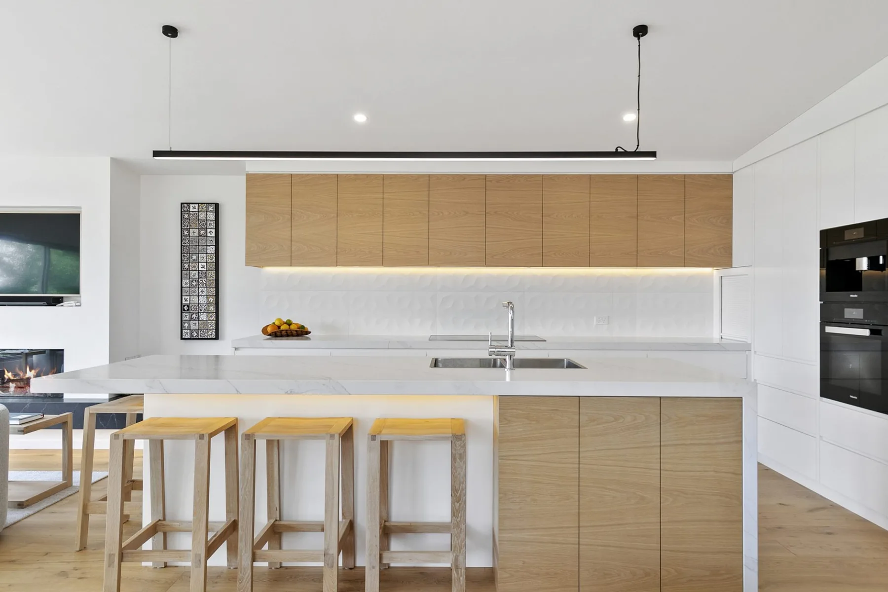 Una cocina moderna y luminosa con una isla amplia y gabinetes de madera.