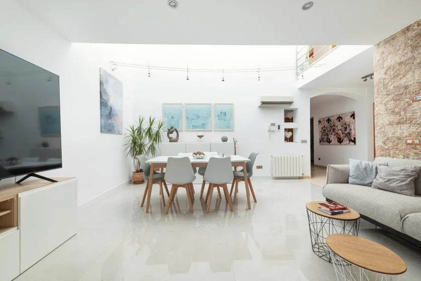 Una luminosa sala-comedor de concepto abierto con una mesa y asientos.