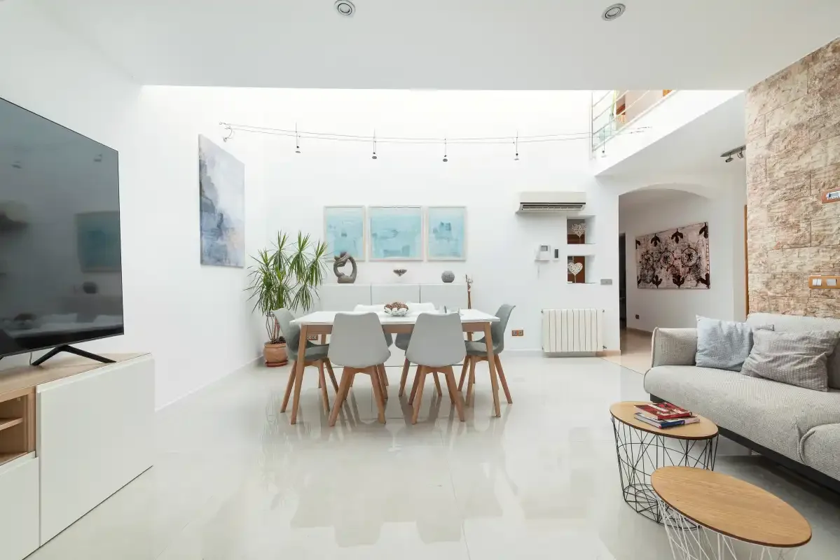 Una luminosa sala-comedor diáfana con una mesa y asientos.
