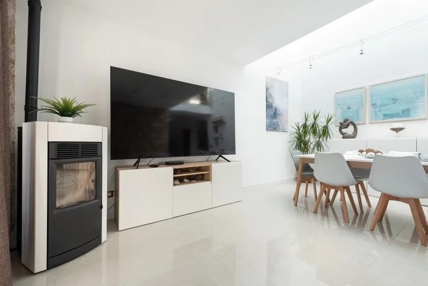 Una luminosa sala de estar y comedor cuenta con un televisor y una mesa de comedor.