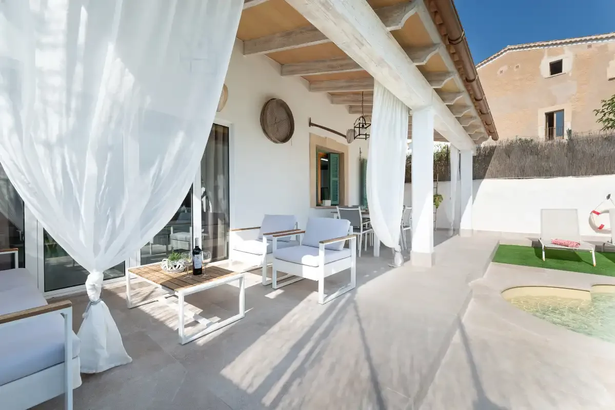 Un patio cubierto tiene asientos al aire libre junto a una piscina pequeña.