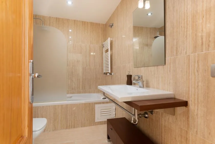Un baño con lavabo, espejo y bañera.