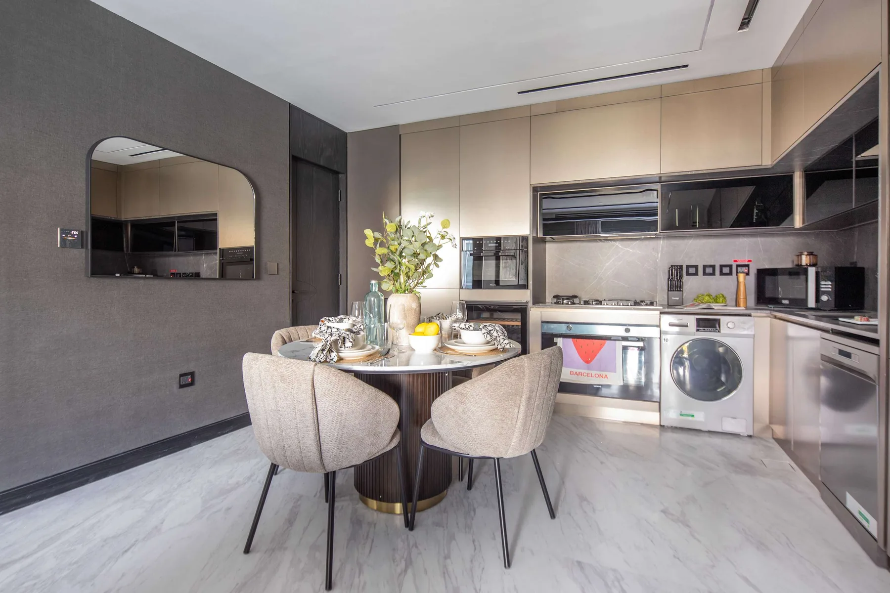 Una cocina moderna con comedor y una mesa puesta junto a los electrodomésticos.