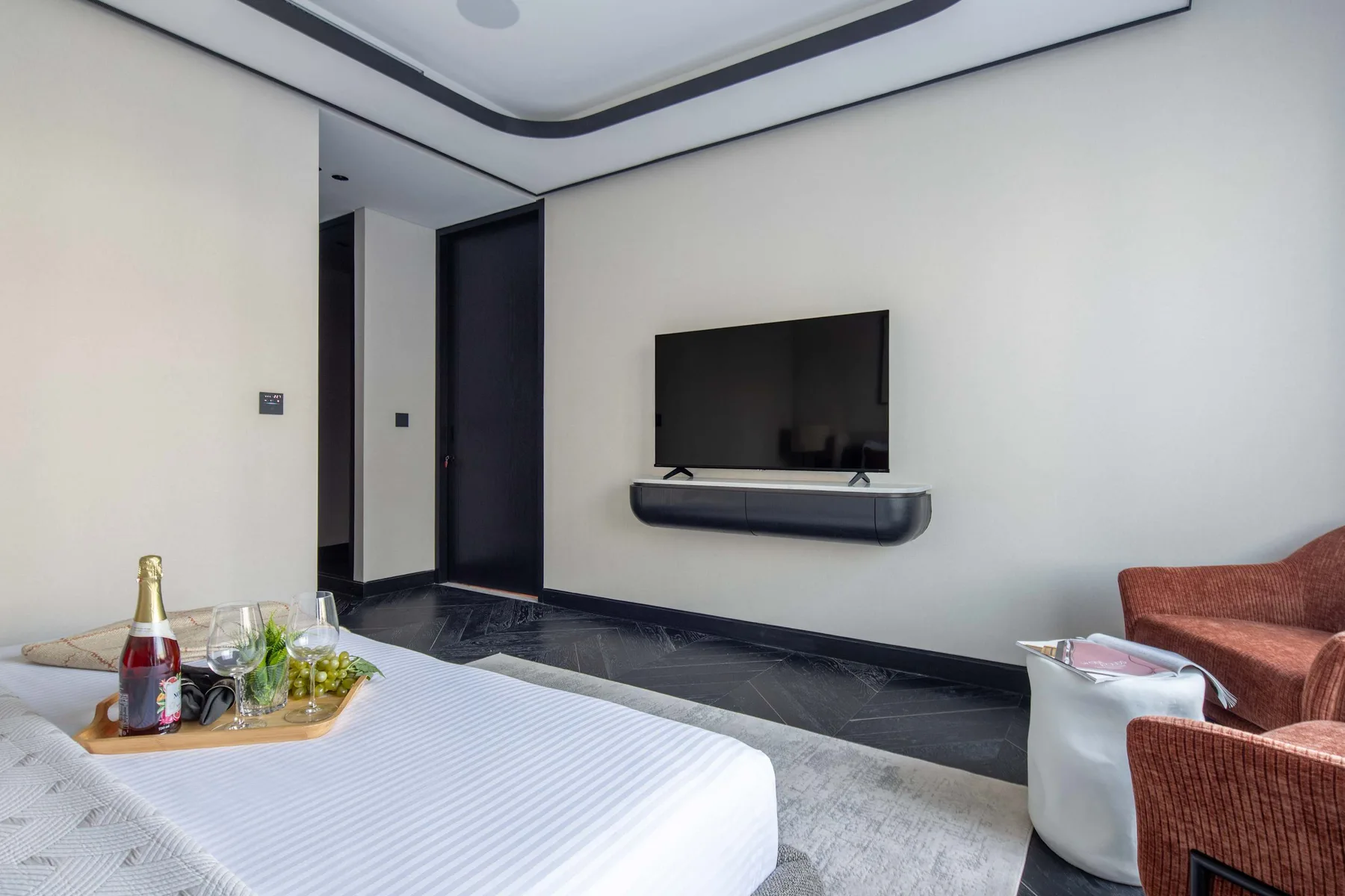 Un dormitorio moderno con un televisor sobre una repisa flotante.