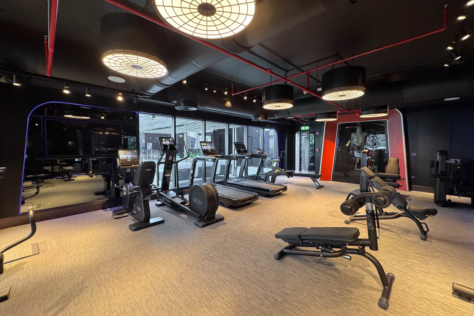 Una sala de fitness moderna con máquinas de ejercicio y equipo para entrenar con pesas.
