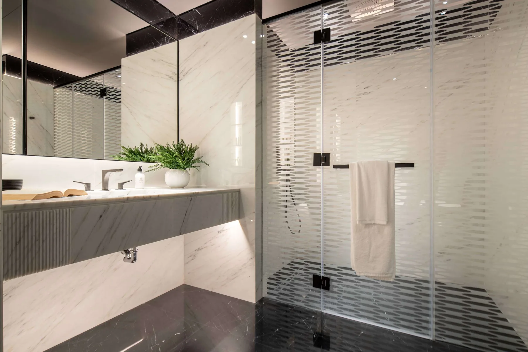 Un baño moderno con un lavabo amplio y una ducha de vidrio.