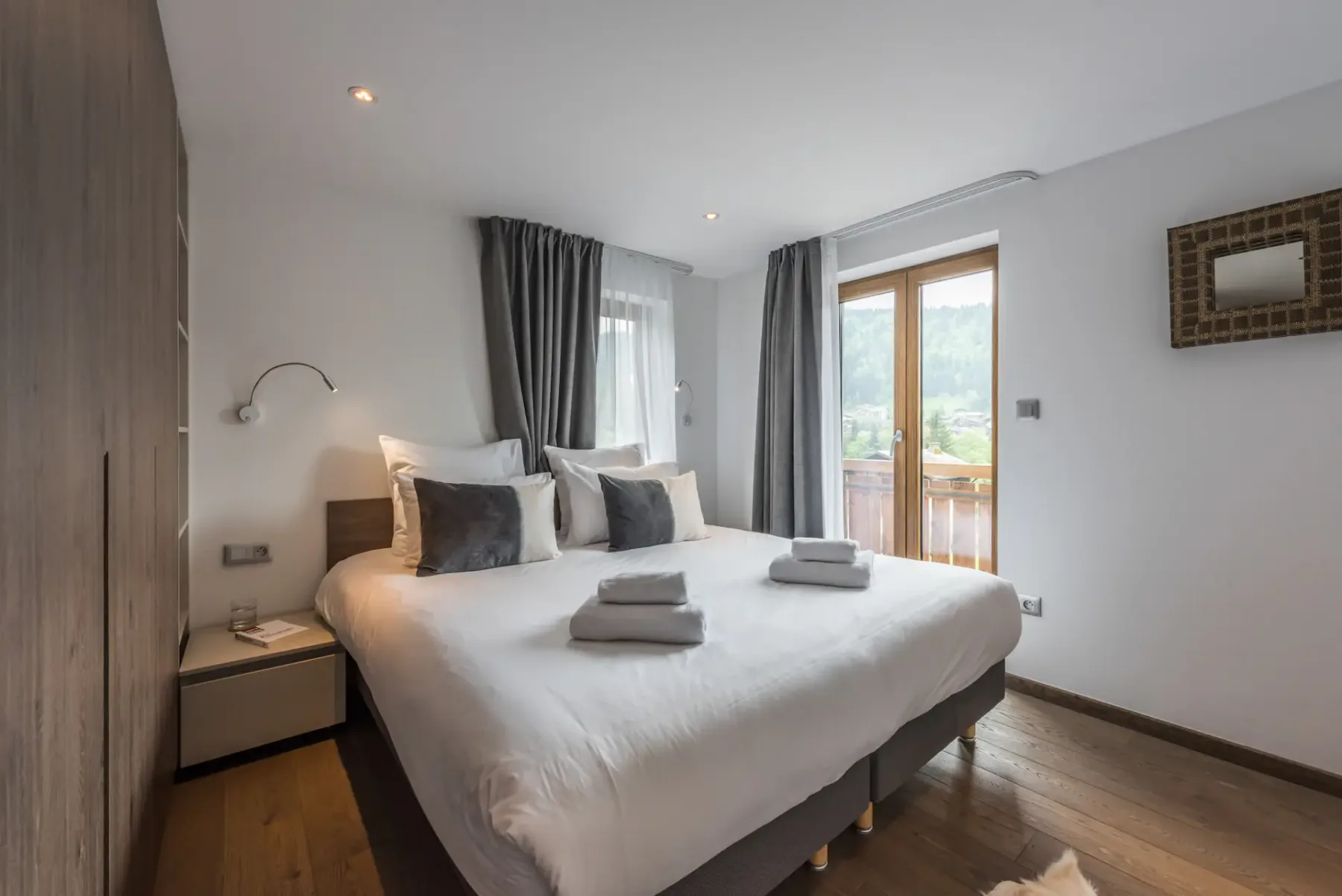 Acogedor dormitorio doble con amplio espacio de armario y vistas al paisaje del apartamento con servicios hoteleros Sugi en Morzine