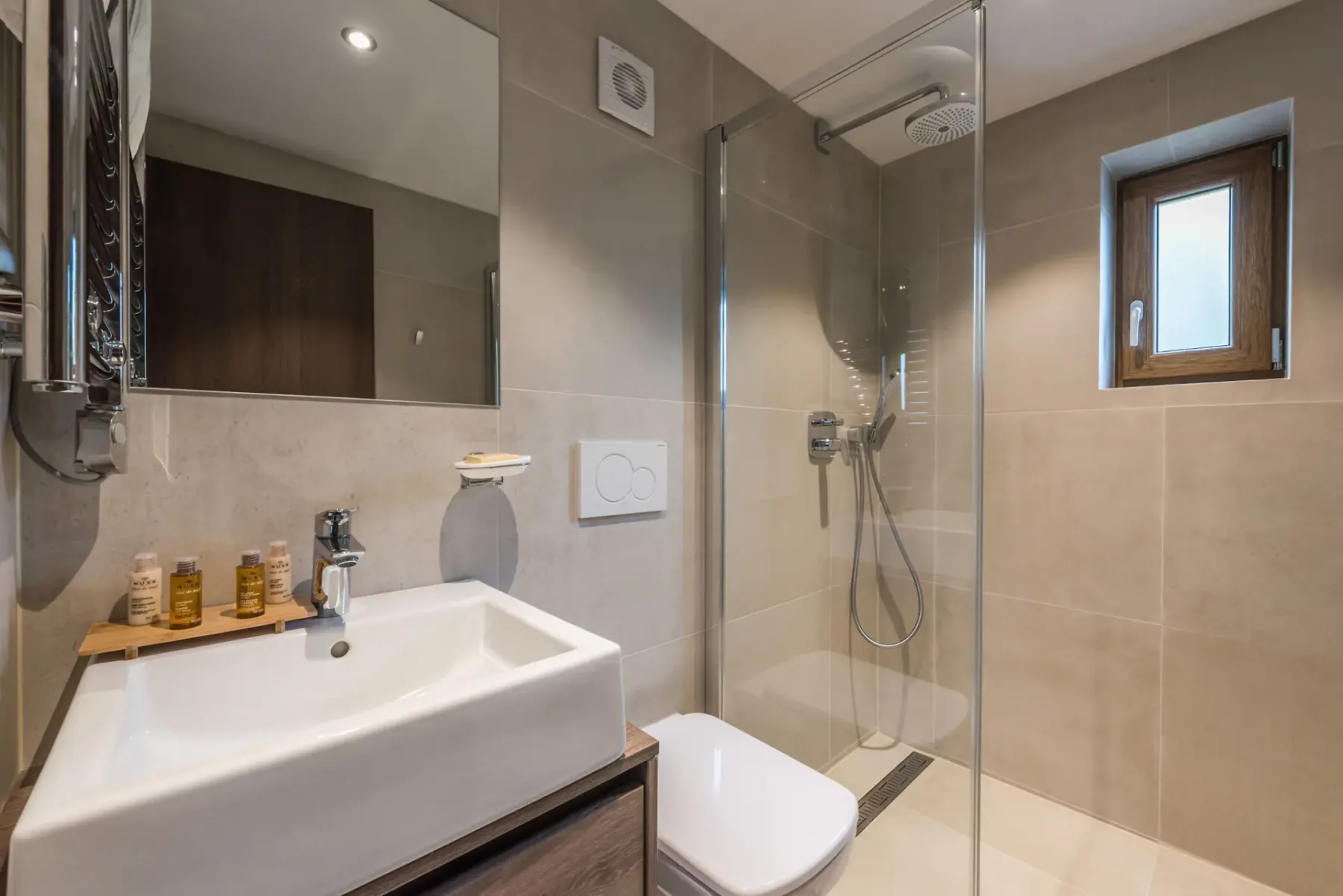 Un baño moderno con lavabo y ducha con mampara de vidrio.