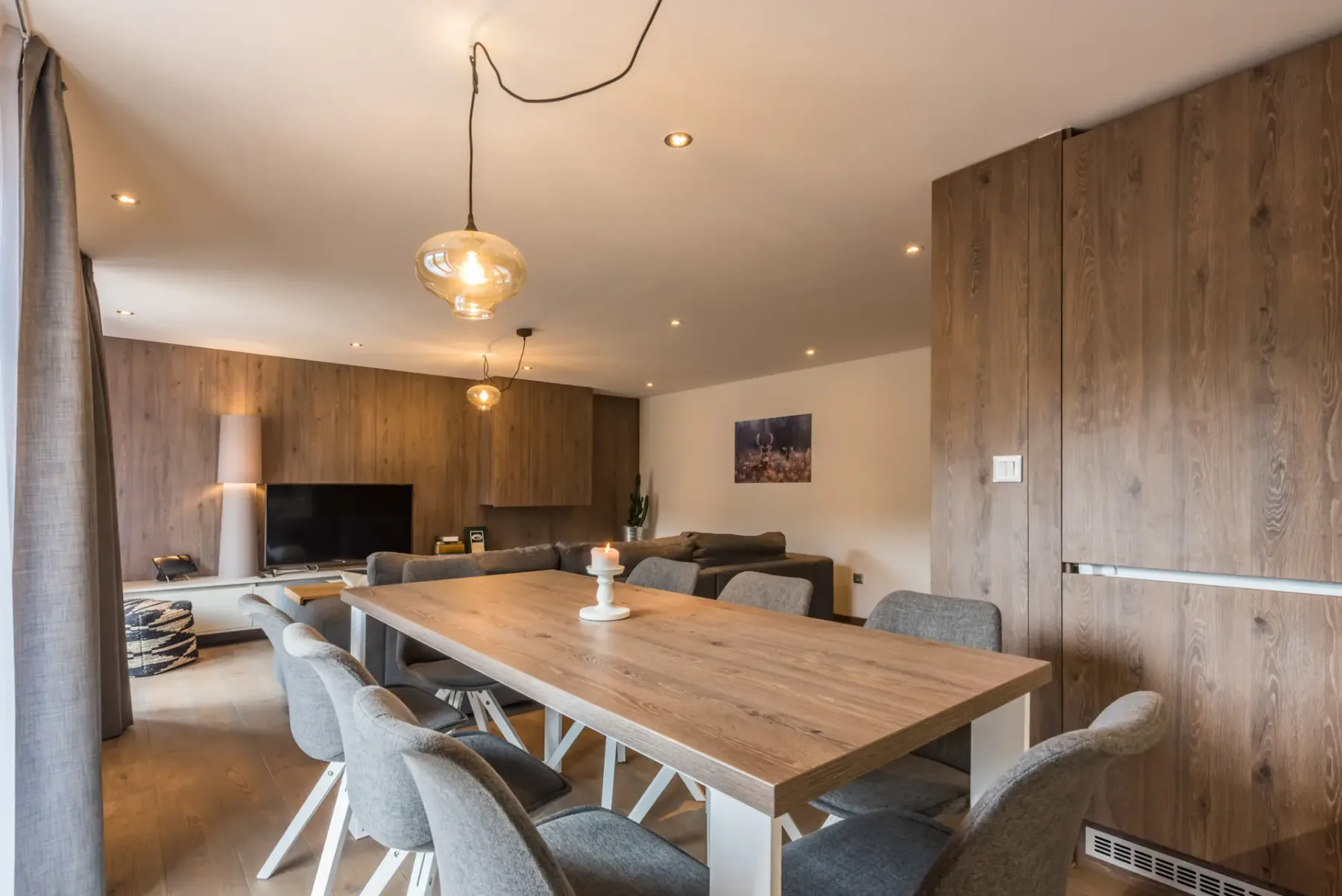 Un comedor con una mesa larga de madera y asientos tapizados.