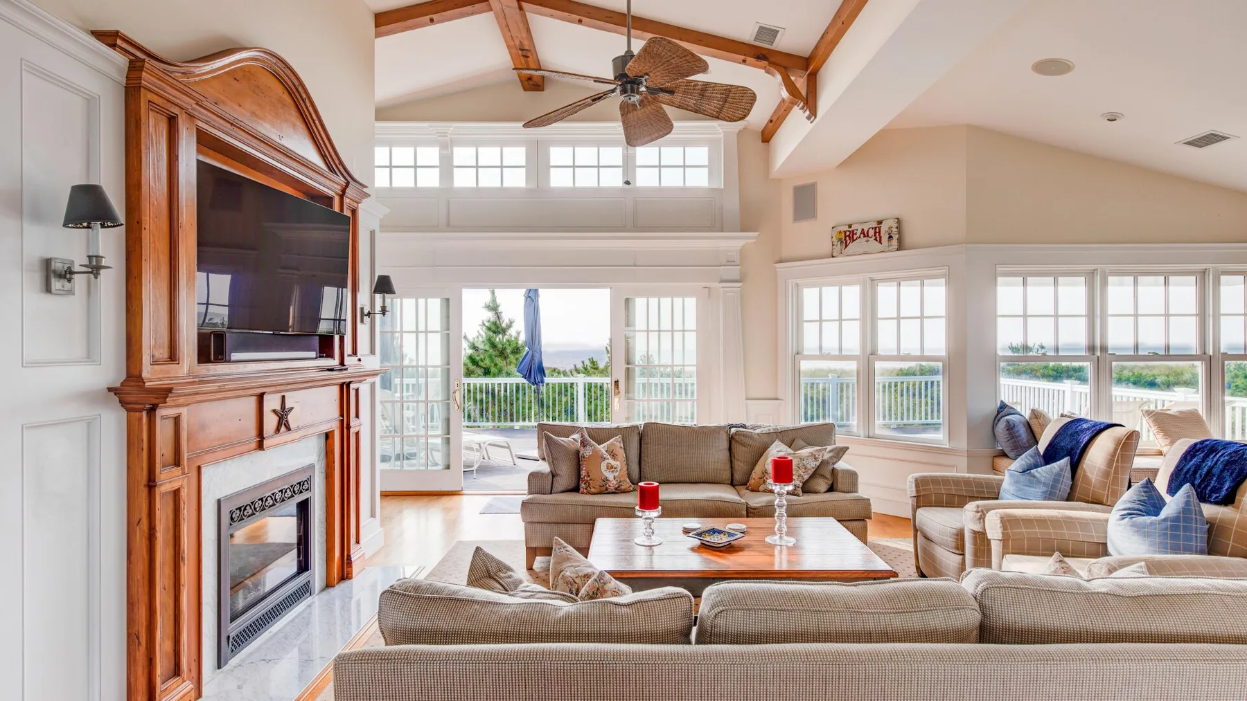 A bright living room with seating arranged around a coffee table and fireplace.