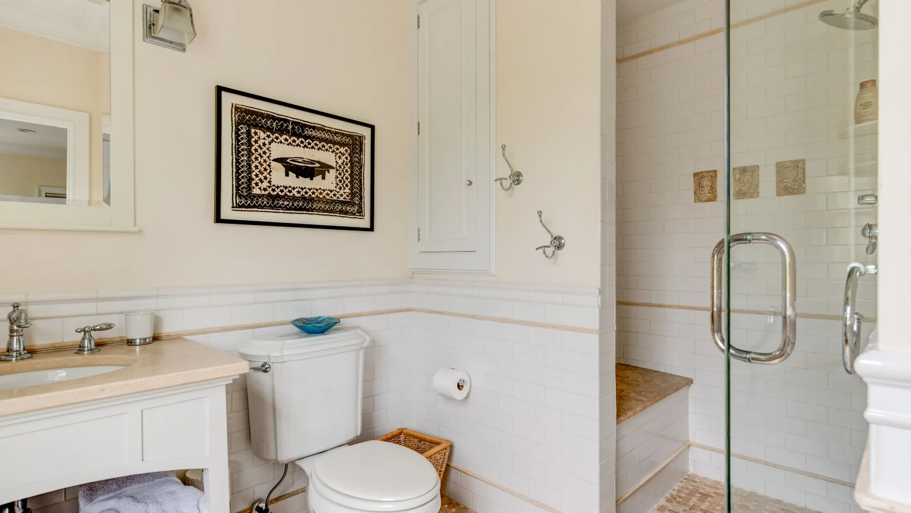 Un baño con lavabo, inodoro y ducha con mampara de vidrio.