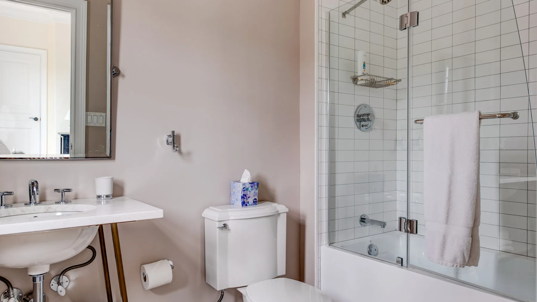 Un baño con lavabo, inodoro y ducha con mampara de vidrio.