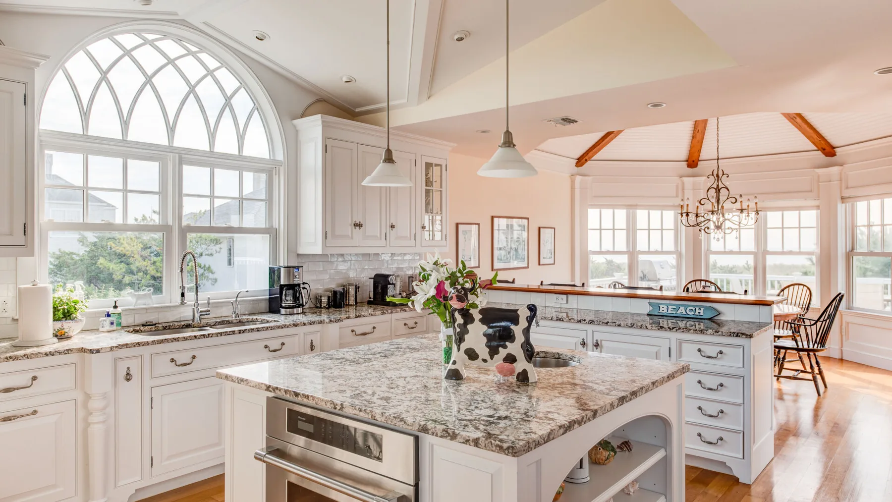 Una cocina luminosa con gabinetes blancos y una gran isla central.